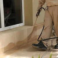 General pest control technician spraying exterior perimeter around a home in Philadelphia, PA